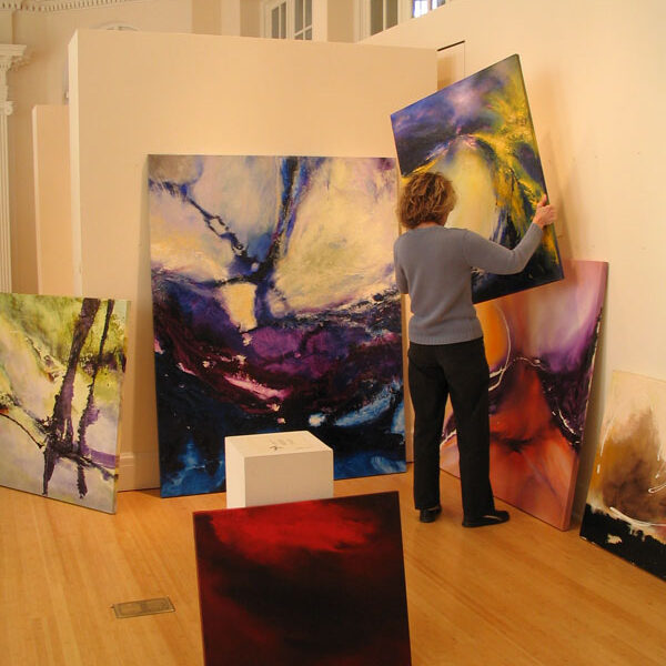 Image of artist installing paintings